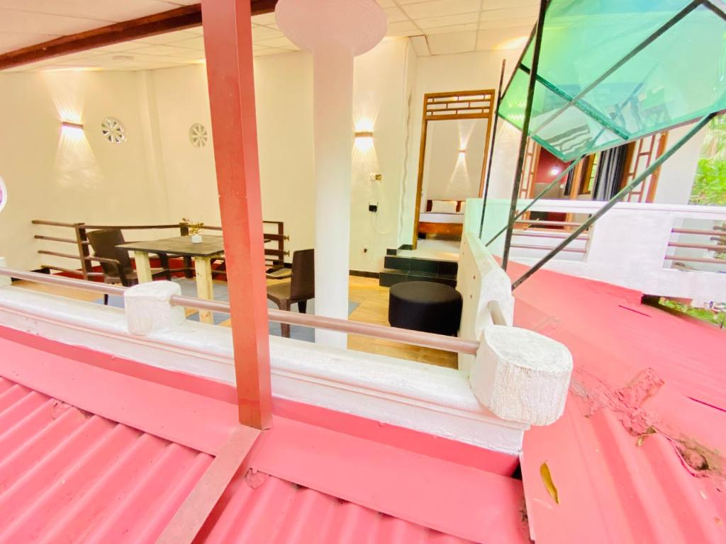 una habitación con techo rosa y una mesa en Rest and Recharge homestay airport transit katunayaka, en Minuwangoda