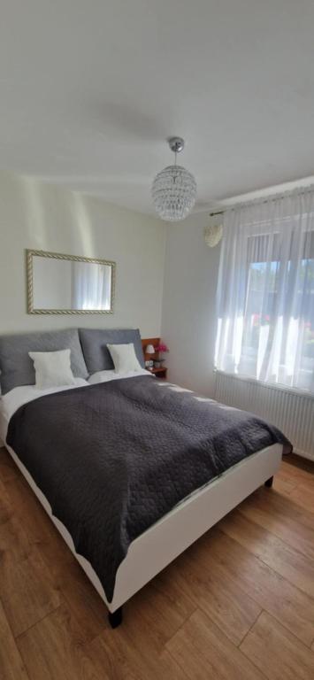 a bedroom with a large bed with a black blanket at JULIANNA APARTMAN Budapest FREE PARKING in Budapest
