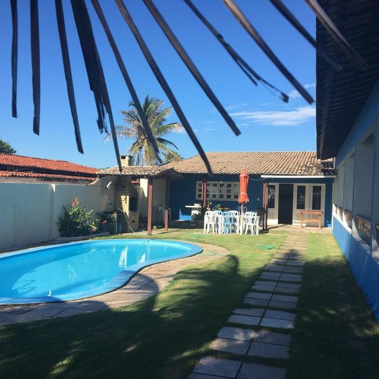 a backyard with a swimming pool and a house at Pousada Soleil de Genipabu in Contenda
