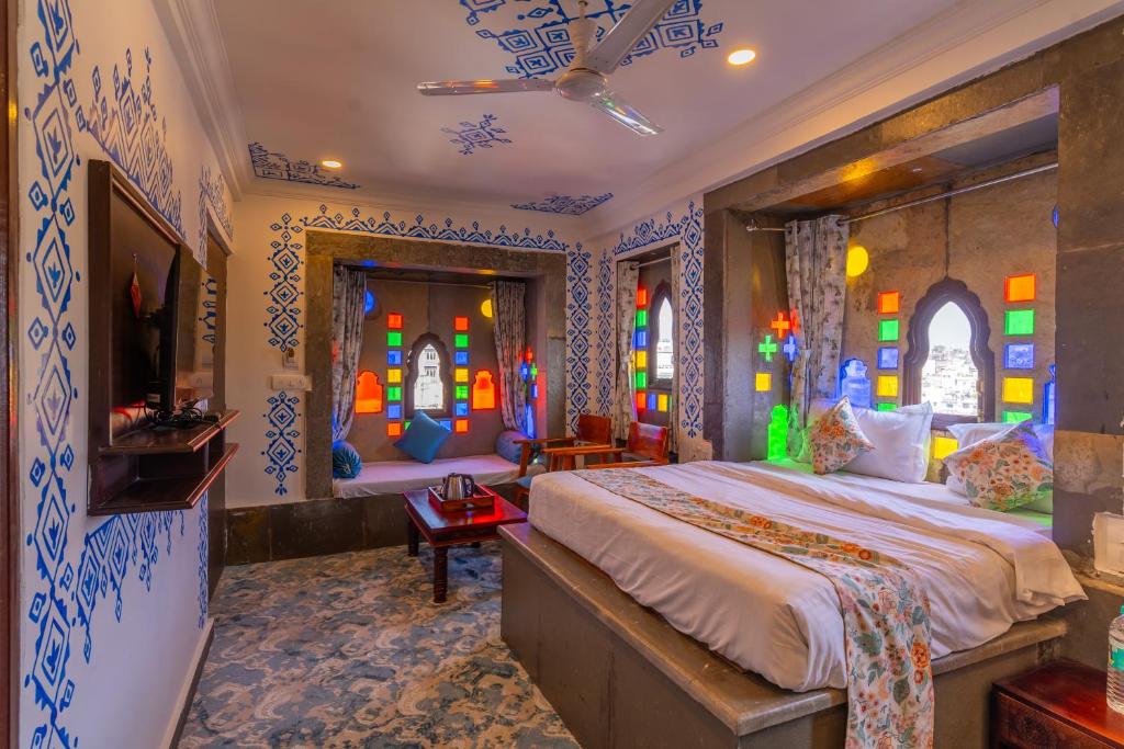 a bedroom with a bed and stained glass windows at Storica Stays Panorama Haveli Udaipur in Udaipur