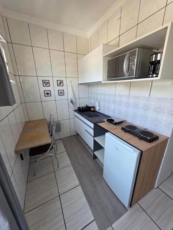 a kitchen with a counter and a microwave at Kitnet na Zona Industrial Sorocaba in Sorocaba