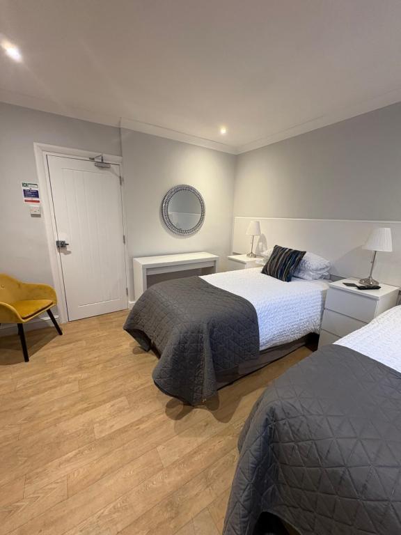 a bedroom with two beds and a fireplace at Watts Lodge in Bicester