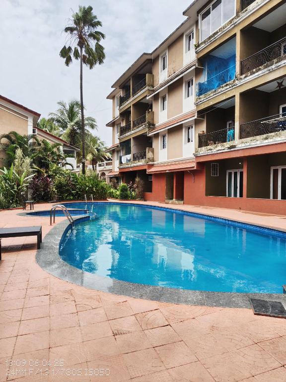 a large blue swimming pool in front of a building at Calangute 3bhk Villa Goa in Candolim