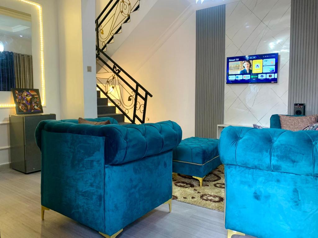 a living room with two blue couches and a tv at Reagal Apartments, WMachine, WiFi, 13 mins DRV from Ikeja, OPIC ESTATE in Agege
