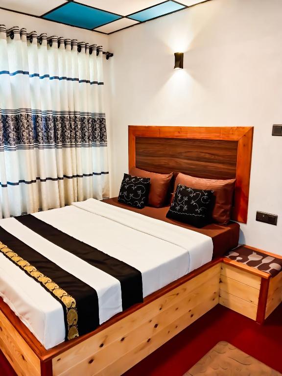 a bedroom with a wooden bed and a curtain at Evergreen Resort Ella in Ella