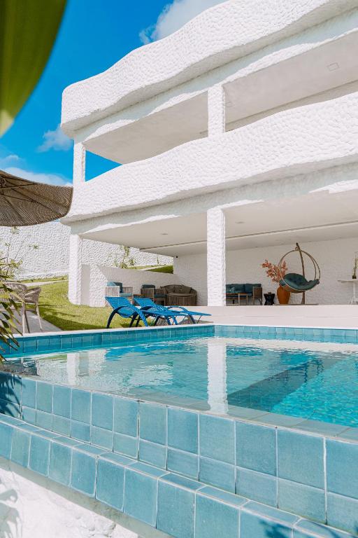 a swimming pool in front of a house at KEFI POUSADA in Maragogi