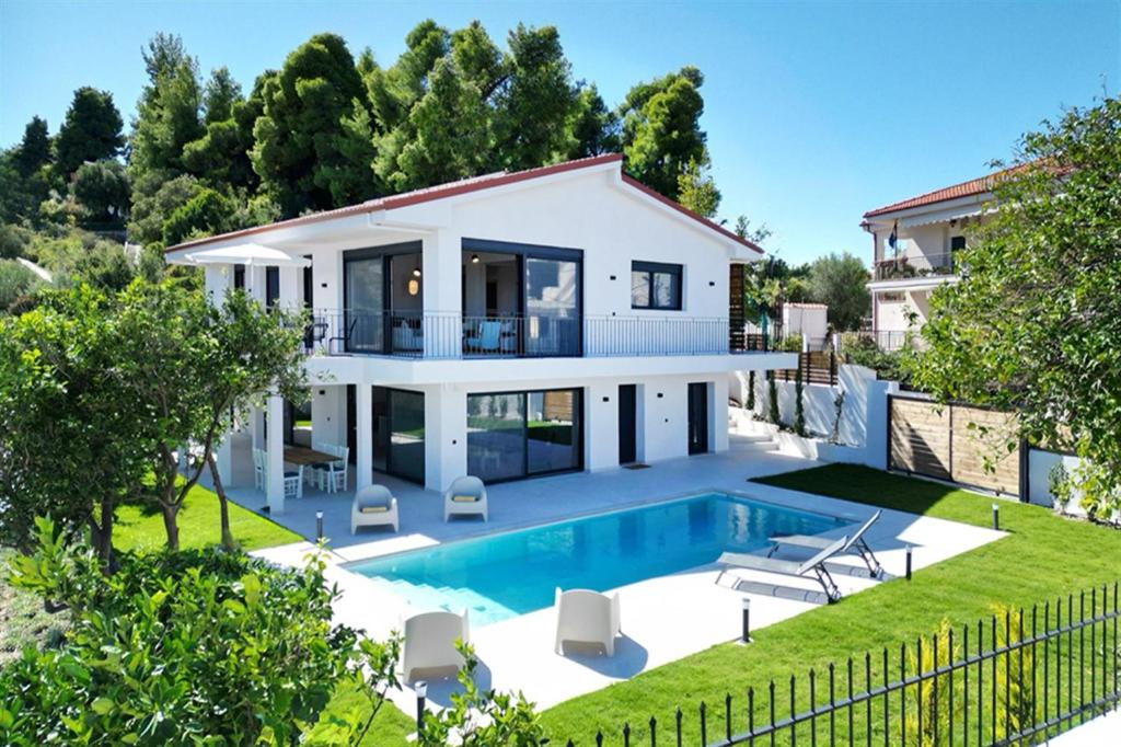 a villa with a swimming pool and a house at Mandarini Luxury Villa Pefkochori 5 bedrooms 12 guests in Pefkohori