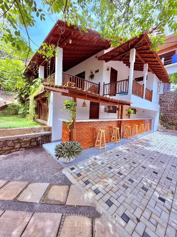 a house with a balcony and a patio at Emma's Sea View in Hiriketiya