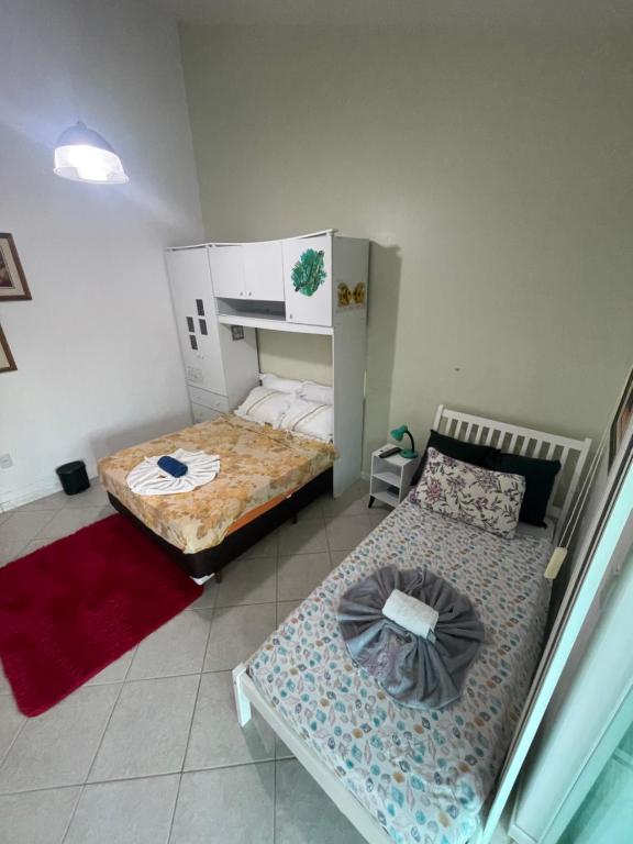 two beds in a small room with at A Pérola do Gravatá in Navegantes