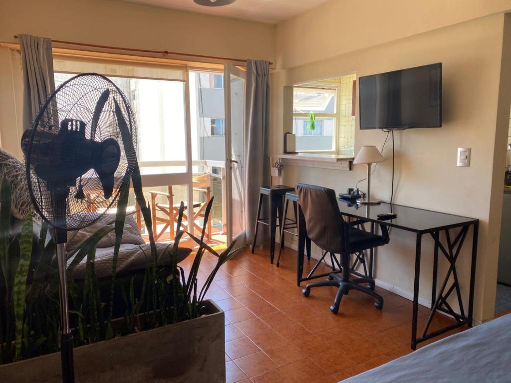 ein Wohnzimmer mit einem Tisch, Stühlen und einem Schreibtisch in der Unterkunft Monoambiente Zona Güemes in Mar del Plata