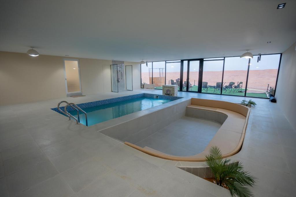 a large room with a swimming pool in a building at Marbella Luxury Desert Camp in Badīyah