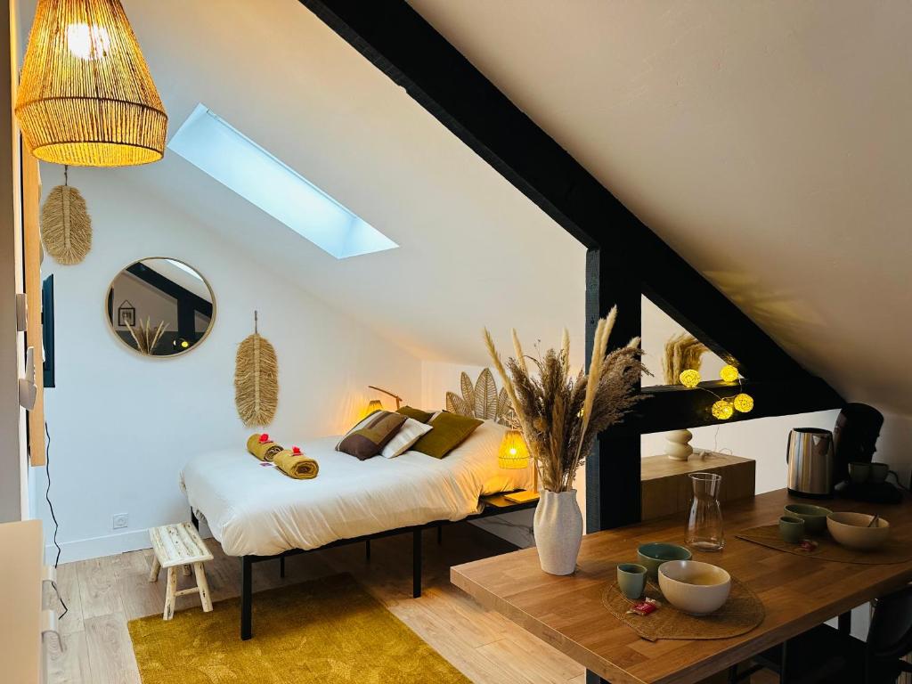 a bedroom with a bed and a table in a room at Le Champêtre - Centre du Rheu in Le Rheu