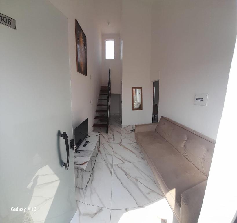 una habitación blanca con suelo de mármol y una escalera en Casa completa, 2 quartos, com ar condicionado, en Hortolândia