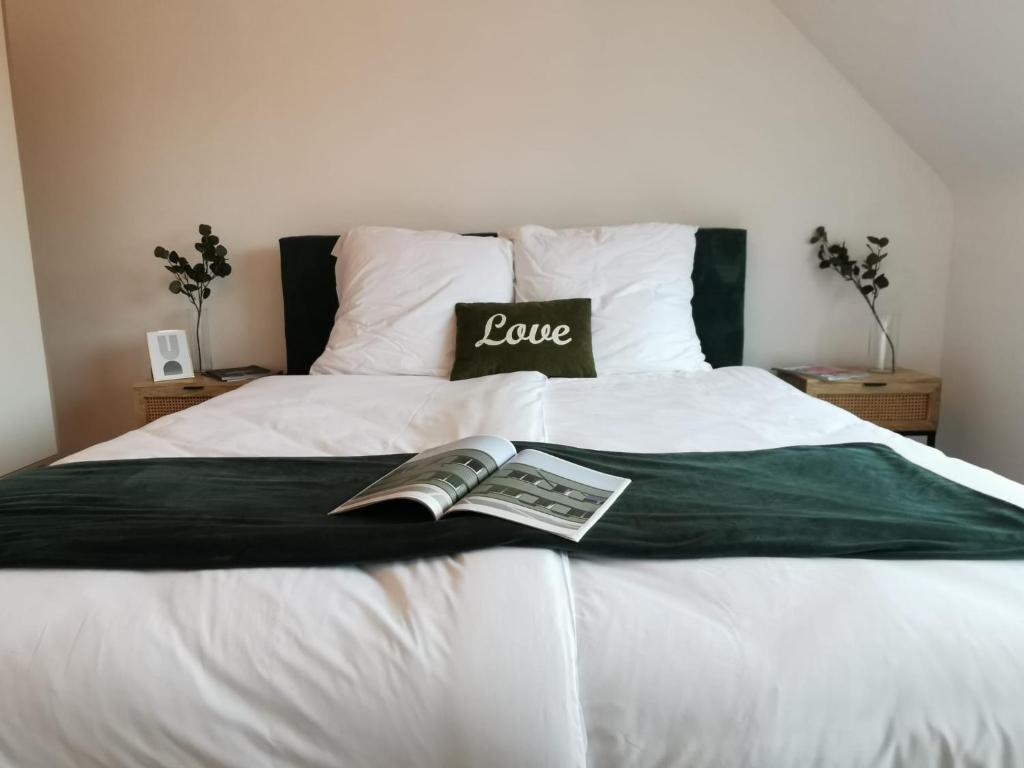 ein Bett mit einem Liebeszeichen und einer Zeitung darauf in der Unterkunft Königstraße Apartments in Nürnberg