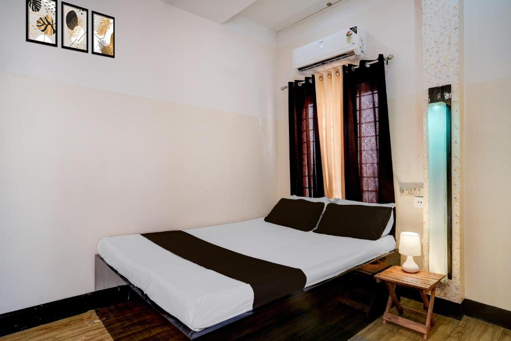 a bedroom with a white bed and a window at Collection O GNRC Hospital Dispur Formerly Shree Vinayak Guest House in Guwahati