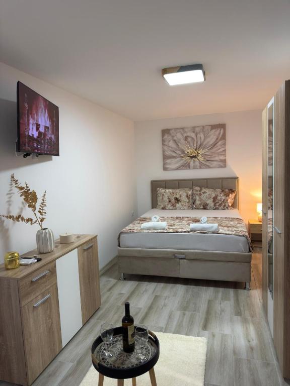 a bedroom with a bed and a table in it at Relax Apartmani Niš in Niš