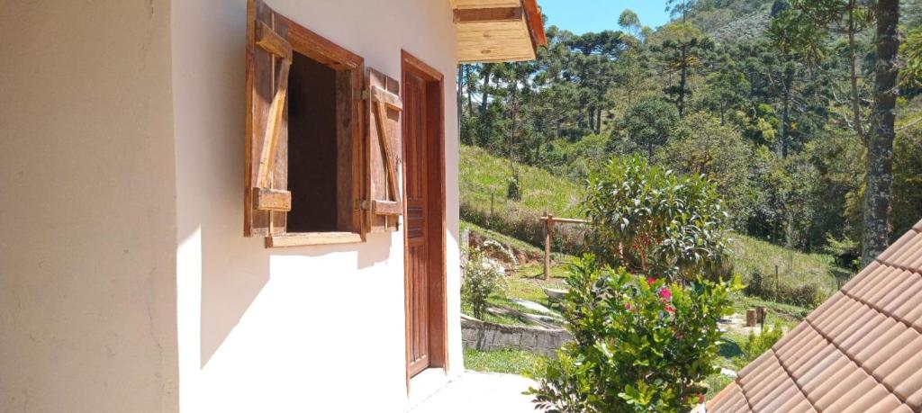 a window of a house with a view of a mountain at Chalé Cogumelo in Visconde De Maua