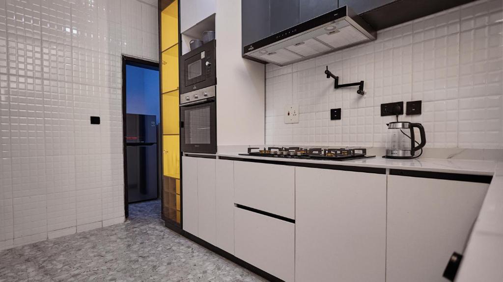 a kitchen with white cabinets and a stove at Jeffreys Apartments in Lagos