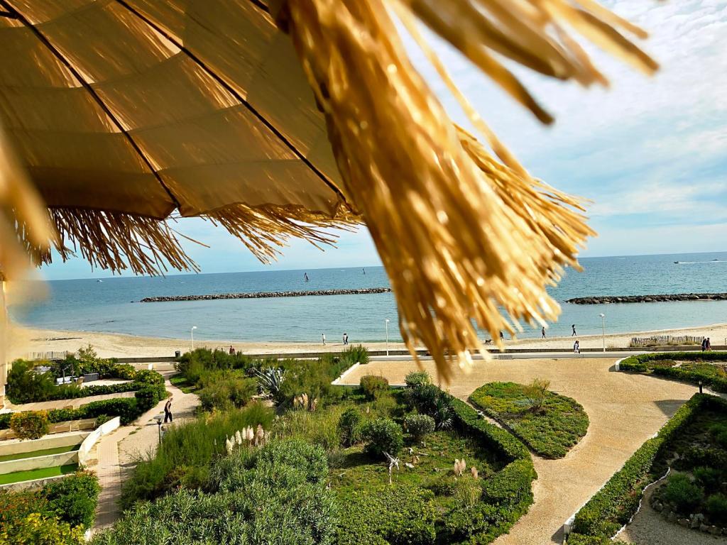 a view of a beach with the ocean in the background at Studio plein sud le ciel le soleil et la mer in Palavas-les-Flots