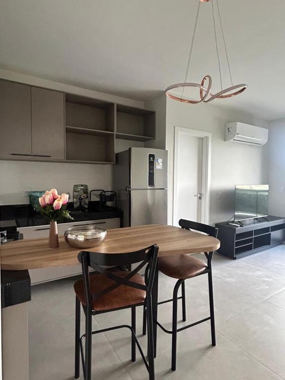 a kitchen with a wooden table and two chairs at Studio em Belém perto do Shopping Bosque e Parque da Cidade in Belém