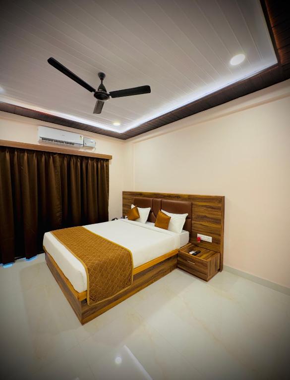 a bedroom with a bed and a ceiling fan at Seaside Beach Resort in Diveagar