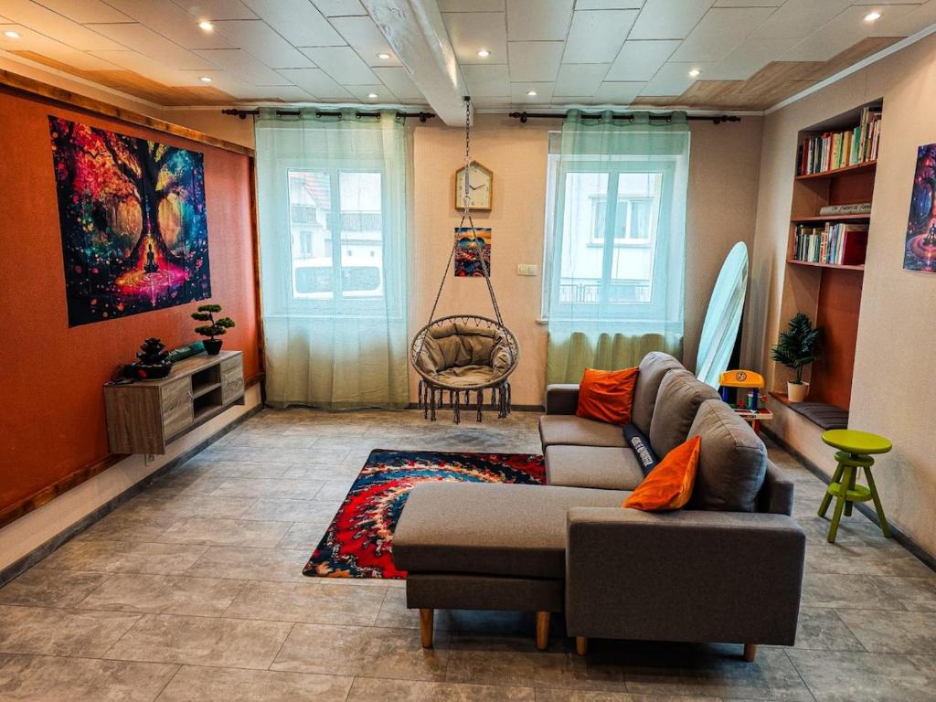 a living room with a couch and a swing at Appartement agréable et atypique, rénové, wifi, terrasse, jardin in Schleithal