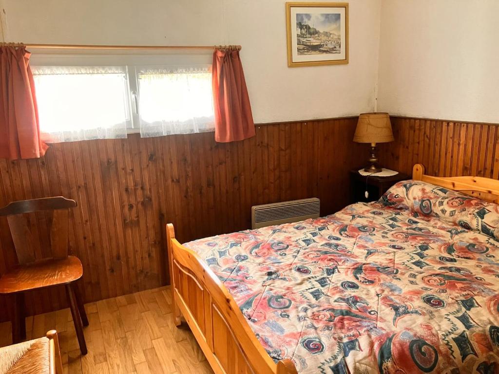 a bedroom with a bed with a floral comforter at Chalet authentique au cœur du Mont d'Or in Métabief