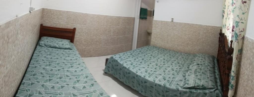 a bedroom with two beds in a room at Kintal da Ka in São Sebastião