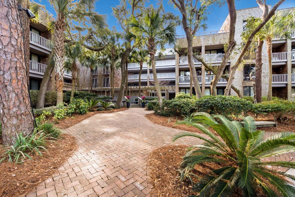 a walkway in front of a building with palm trees at 2371 Shipwatch Villa by Akers Ellis Rentals in Kiawah Island