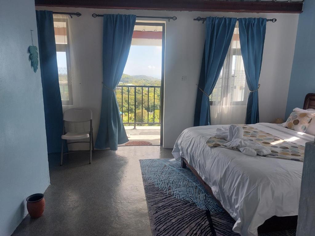 a bedroom with a bed and a sliding glass door at Baz-Art Eco Guest House in Tambe