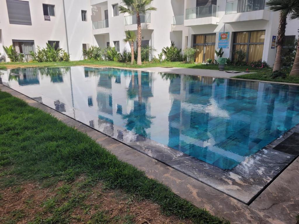 a swimming pool in front of a building at Studio Luxe Nouaceur in Nouaseur