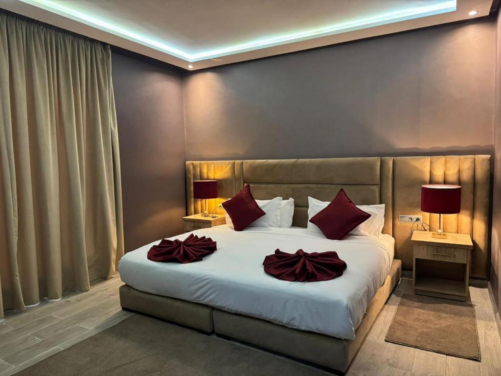 a bedroom with a large white bed with red pillows at RS Hôtel Karam Resort in Ouarzazate