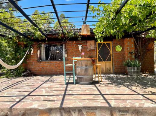 a patio with a table and a barrel at Cabañas Claudia in Valle de Guadalupe