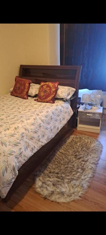 a bed with two pillows on it with a rug at Beautiful home feeling No 62 in Croydon