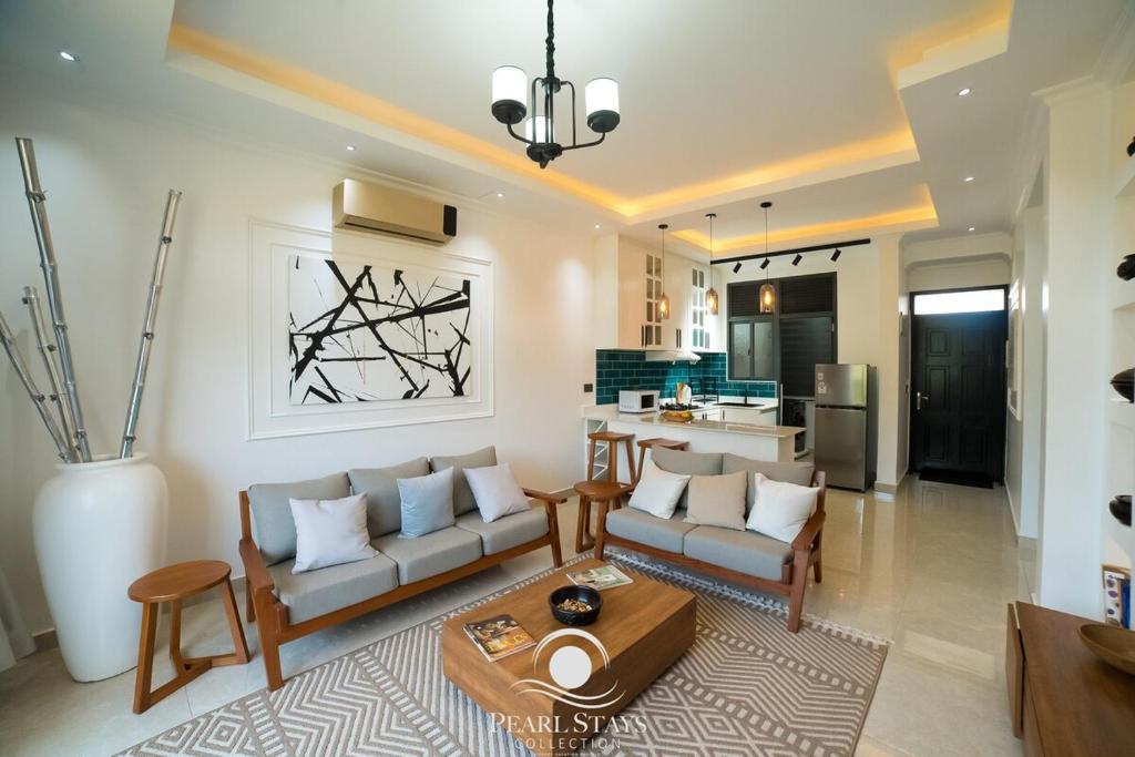 a living room with a couch and a table at Lakeside Serenity Stylish 2BR Getaway - Entebbe in Entebbe