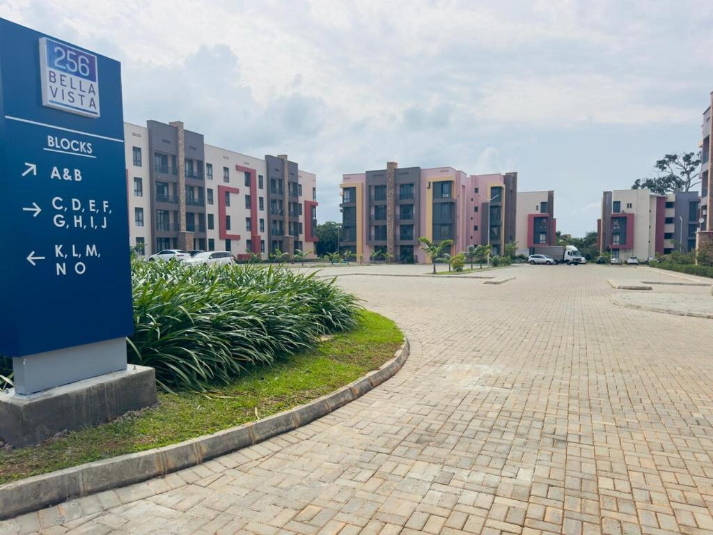 a sign in front of a parking lot with buildings at Lakeside Serenity Stylish 2BR Getaway - Entebbe in Entebbe