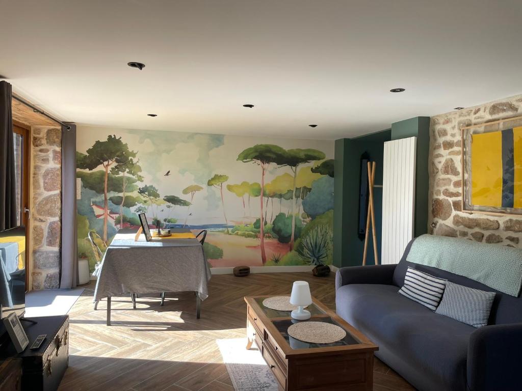 a living room with a couch and a table at Gîtes d Izel N1 entre terre et mer prés d'un golf in Ploemel
