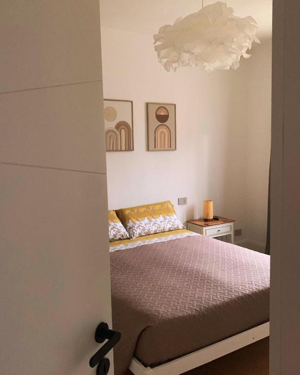 a bedroom with a bed and a chandelier at Il Glicine Bianco in Omegna