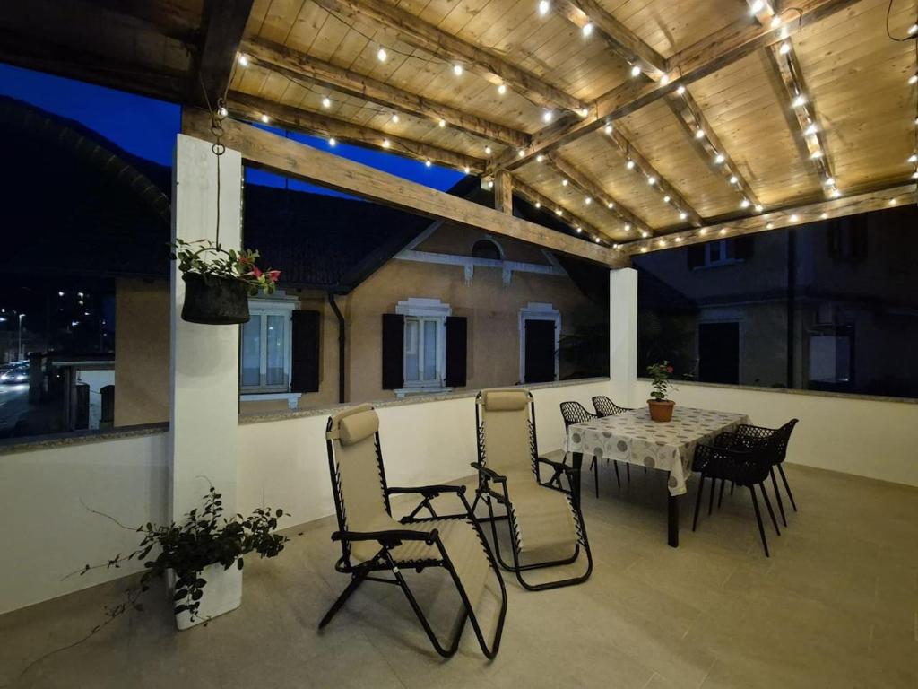 a patio with a table and chairs and lights at Il Glicine Bianco in Omegna