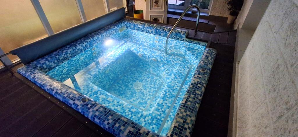 a jacuzzi tub in a bathroom with a blue tile floor at Casa de Piñeiro y SPA Opcional de in Santiago de Compostela