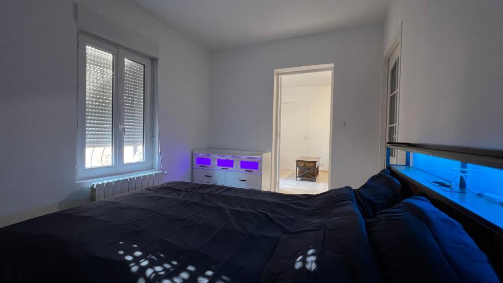 a bedroom with a large bed with purple lights at logis des abeilles sejour-tricastin in Pierrelatte
