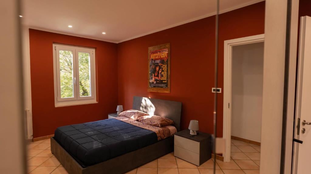 a bedroom with red walls and a bed in it at Spazioso appartamento vicino a tutto in Tortona
