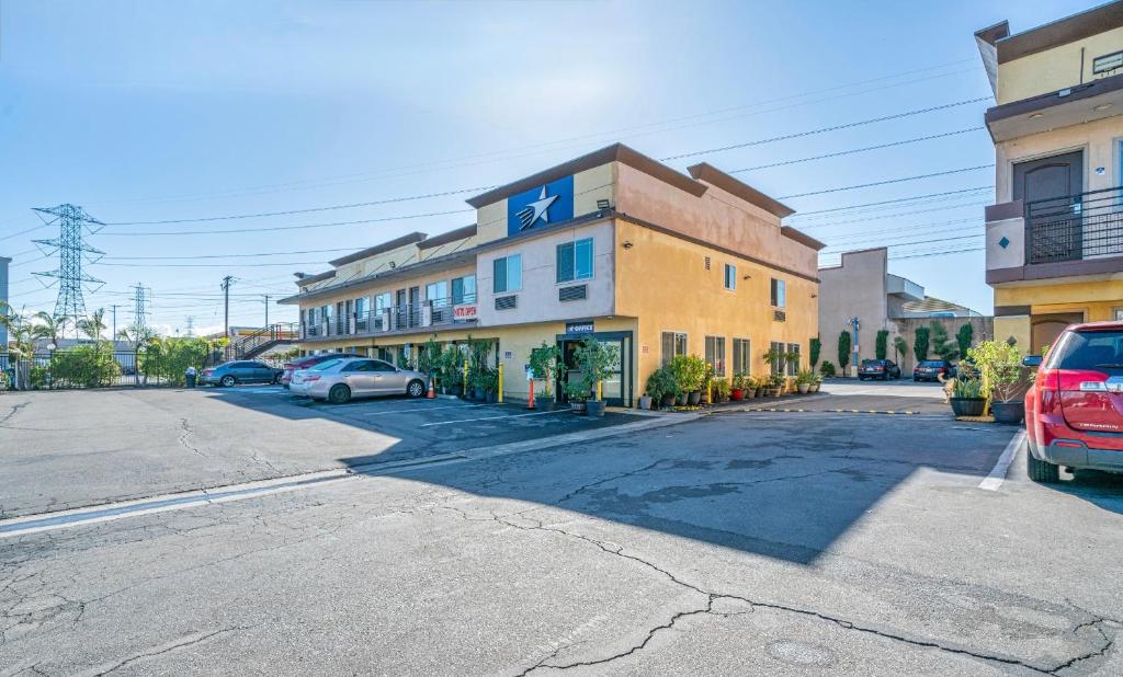 a building on a street with cars parked in a parking lot at Starlight Inn South El Monte in South El Monte