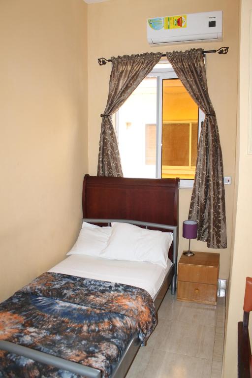 a bed in a room with a window and a bed sidx sidx sidx at Jesiwa B's Little Palace in Accra