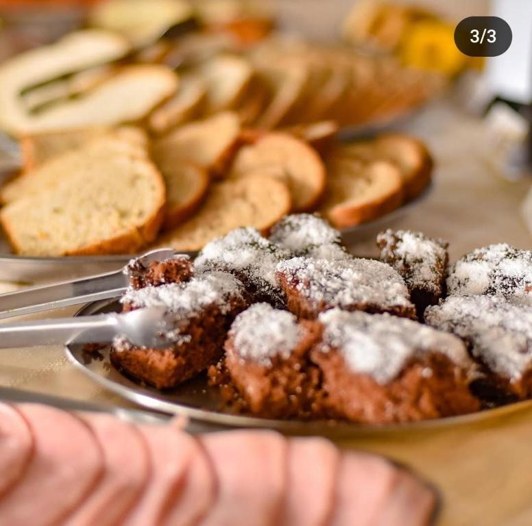 a plate of donuts with powdered sugar on top at Novo Hotel in Caçapava do Sul