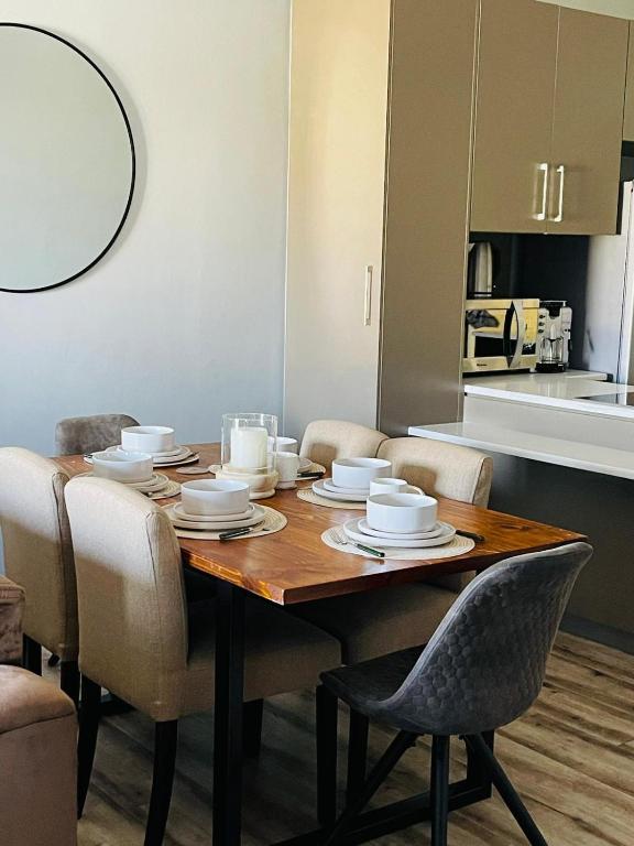 a dining room table with chairs and a kitchen at Merensky Tower Apartment in Windhoek