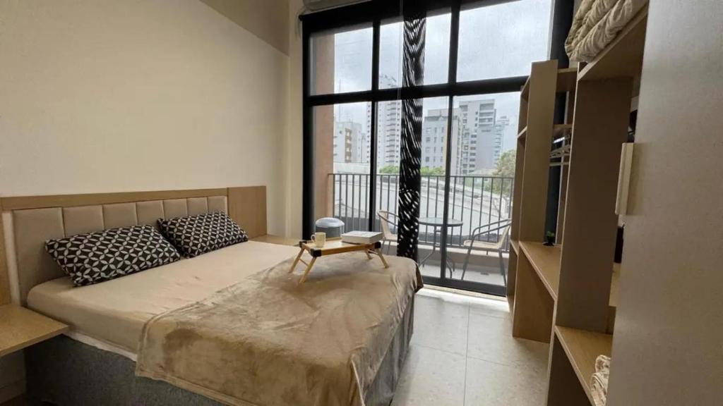 Un dormitorio con una cama y una ventana grande. en Aimbere by You - 20015 - Ótima localização - Allianz Parque - Palmeiras - Perdizes, en São Paulo