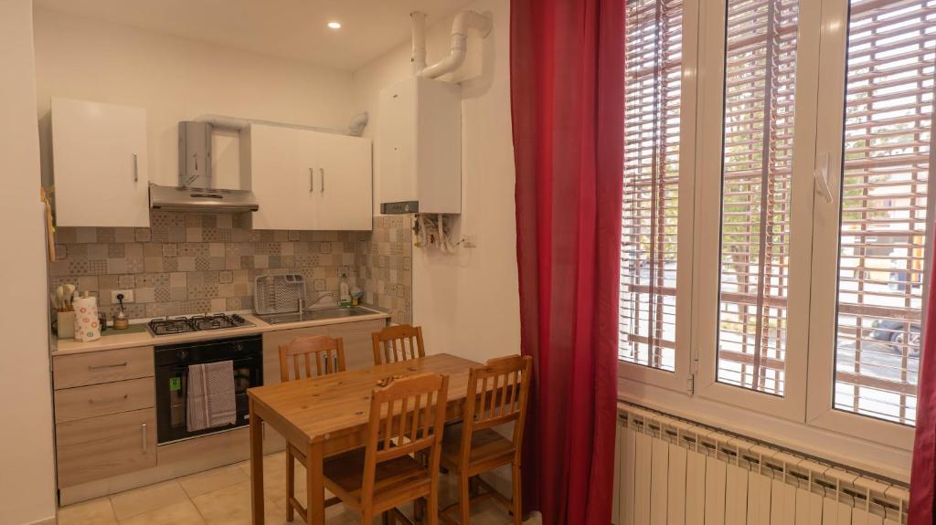 a kitchen with a wooden table and chairs and a kitchen withwindows at Appartamento don orione in Tortona