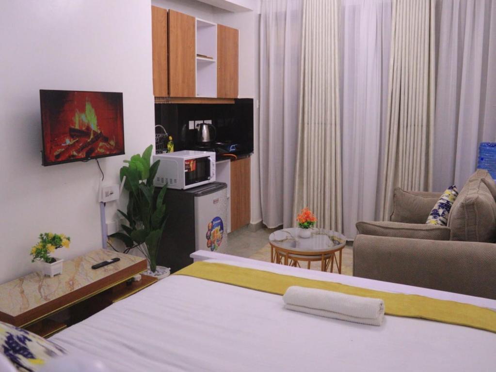 ein Hotelzimmer mit einem Bett und einem Wohnzimmer in der Unterkunft Havenly Homes Stay in Gatunga