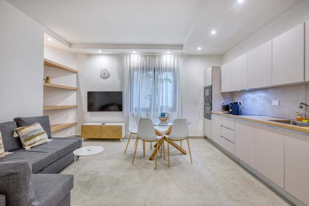una cucina e un soggiorno con un divano e un tavolo di Charming Sliema Sea Escape a Sliema